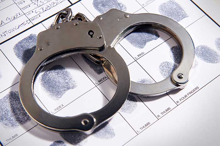Handcuffs kept on paper with multiple fingerprints