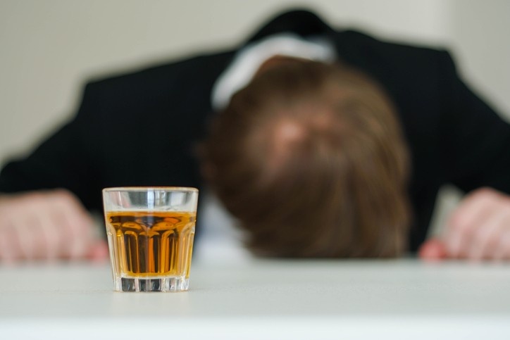 Drunk man sleeping at office desk.